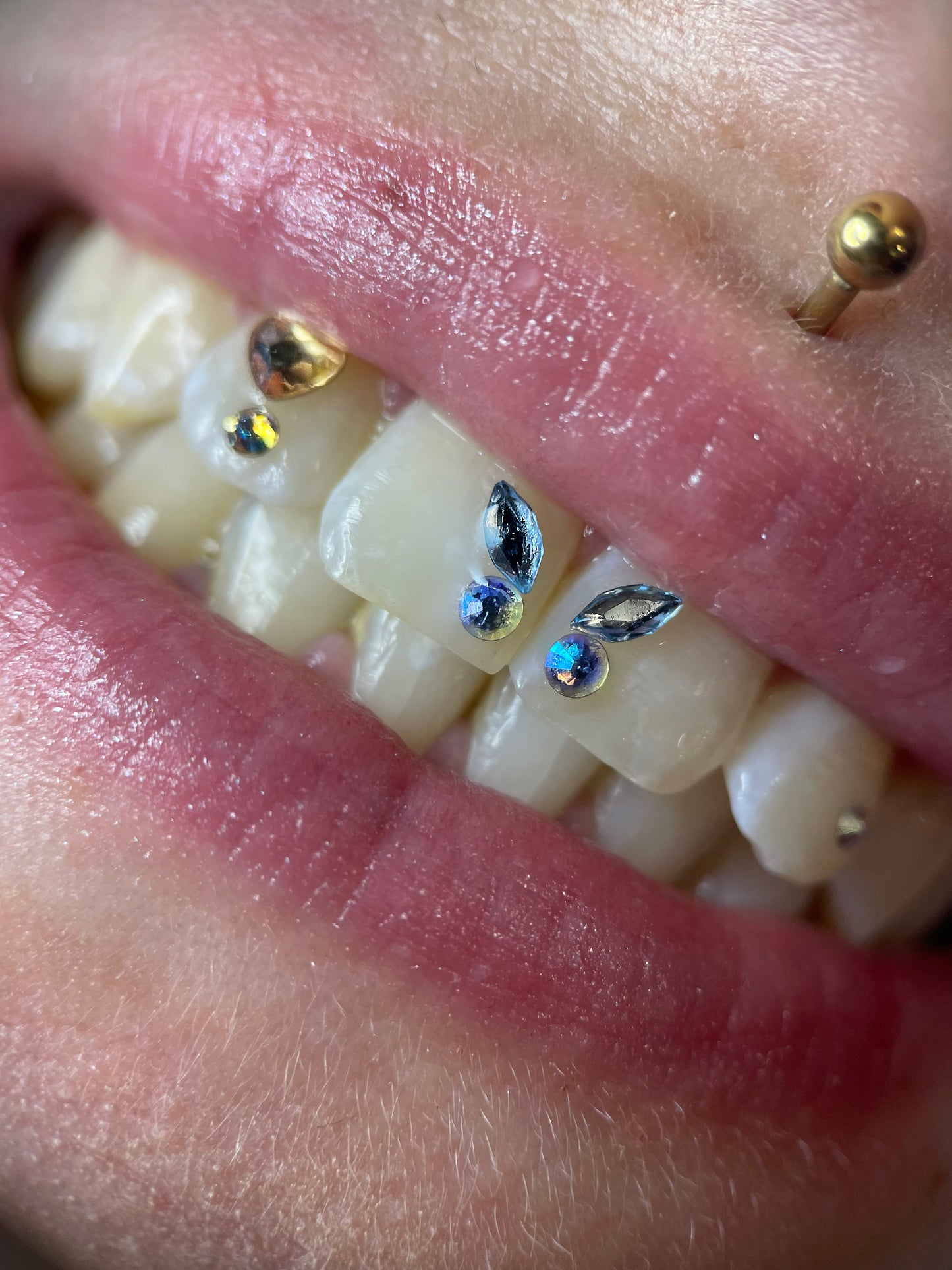 Sourire orné d'un papillon formé avec deux navette swarovski skyblue et deux ronds assortis