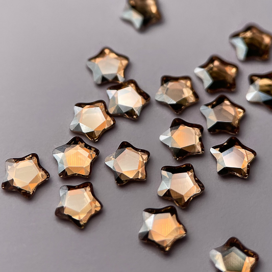 Zoom sur strass dentaire Swarovski en forme de petite étoile, couleur champagne.