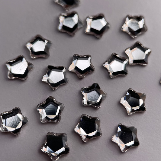 Zoom sur strass dentaire Swarovski en forme de petite étoile, couleur crystal.