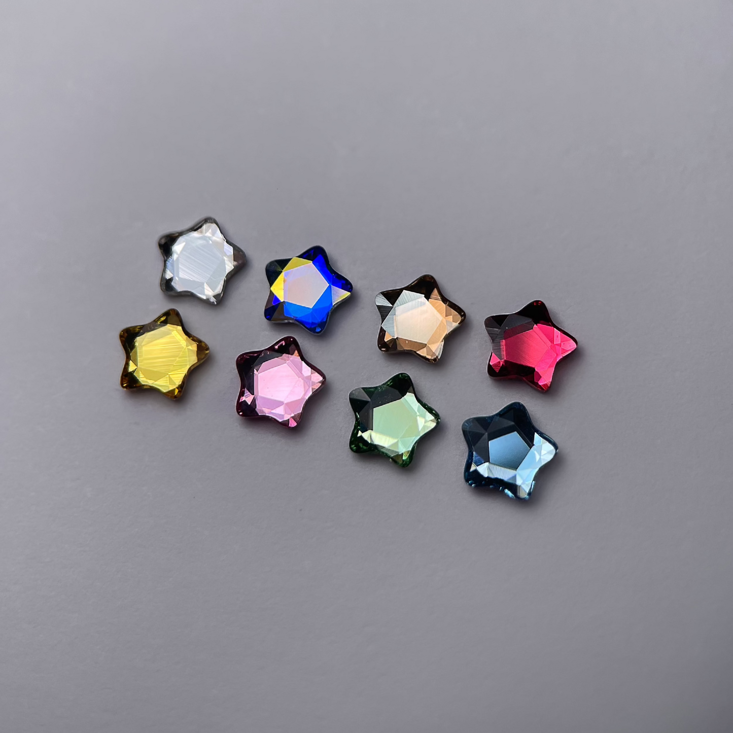 Strass dentaires Swarovski en forme d’étoile, présentés en plusieurs couleurs brillantes.