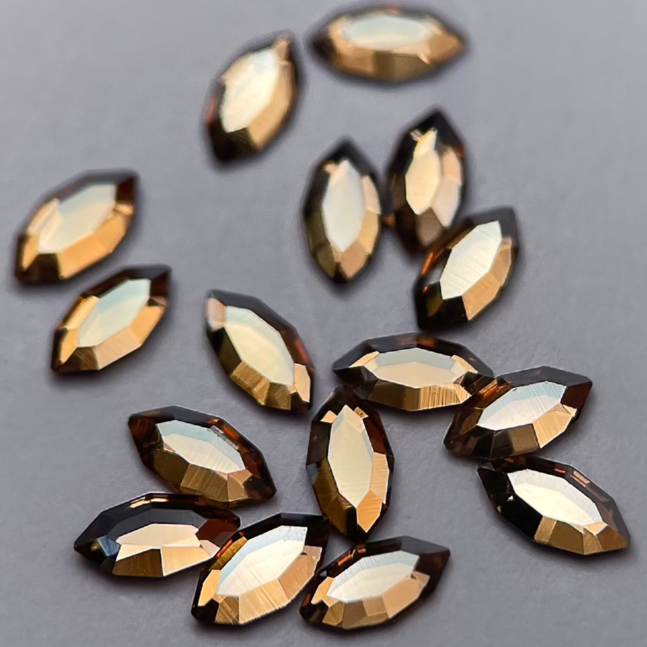 Zoom sur strass dentaire Swarovski en forme de navette, couleur champagne, haute brillance, qualité professionnelle.