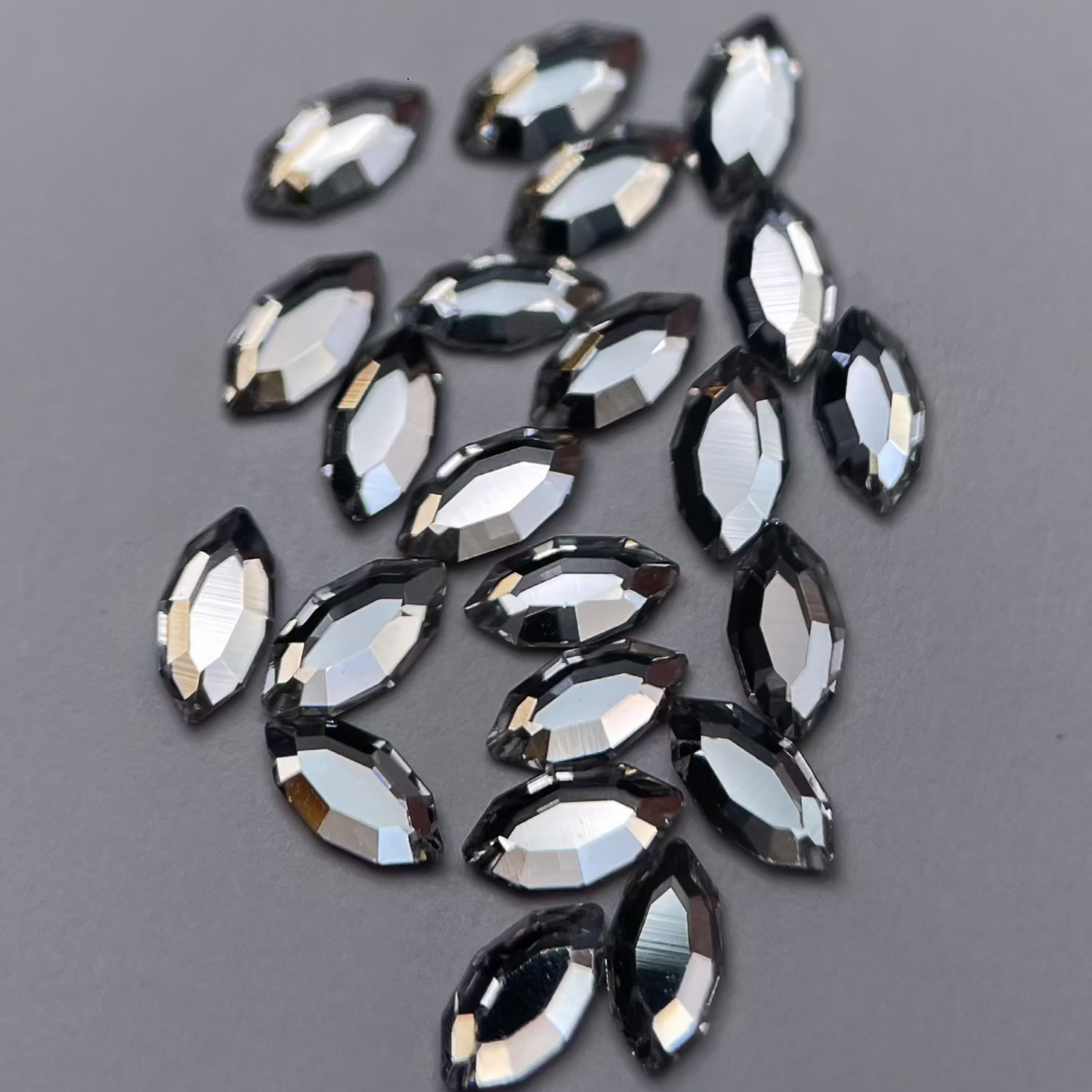 Gros plan sur strass dentaire Swarovski en forme de navette, couleur crystal, haute brillance, qualité professionnelle.