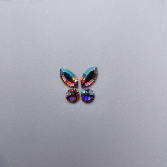 Papillon formé de deux strass navette et deux strass ronds, couleur holographic assortie.