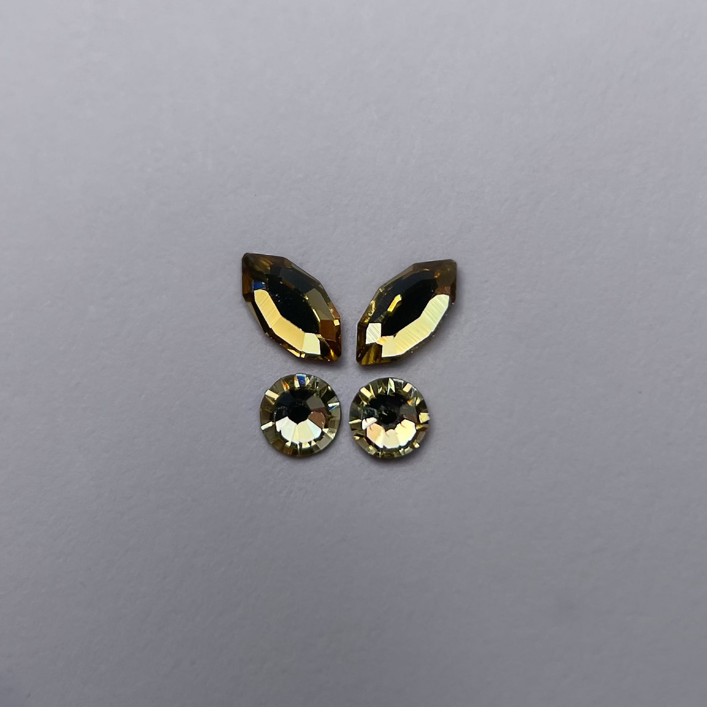 Papillon composé de deux strass navette lemon et deux strass ronds assortis.