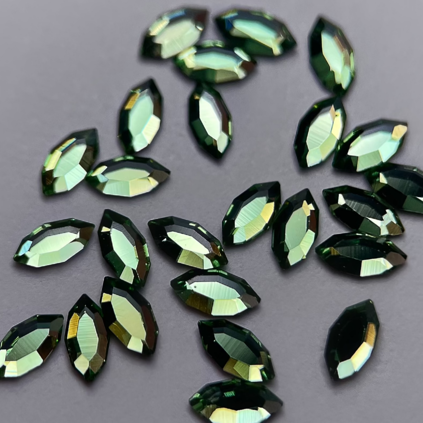 gros plan sur strass dentaire Swarovski en forme de navette, couleur pistachio, haute brillance, qualité professionnelle.