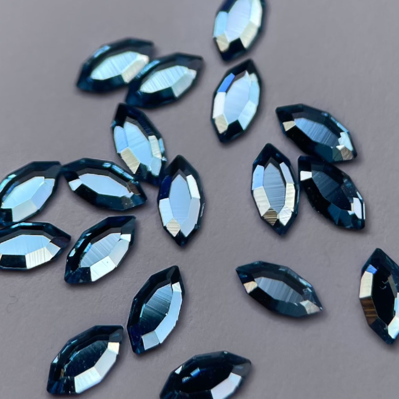 Gros plan strass dentaire Swarovski en forme de navette, couleur skyblue, haute brillance, qualité professionnelle.