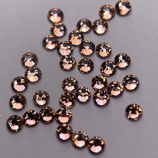 Zoom sur strass rond teinte saumon doré.