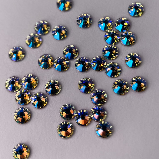 Zoom sur strass rond aux reflets dorés scintillants.