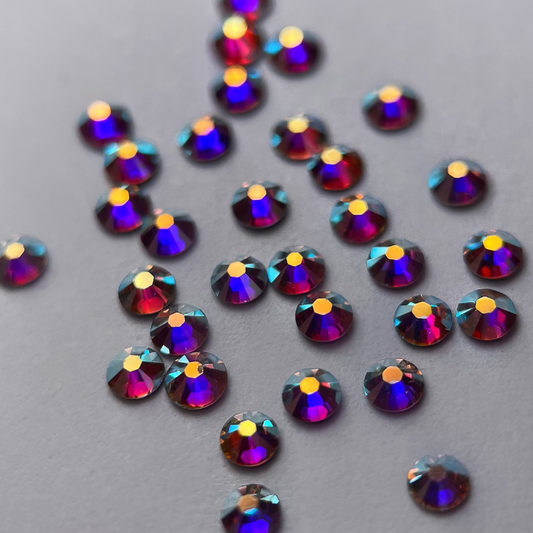 Zoom sur strass rond aux reflets holographiques.