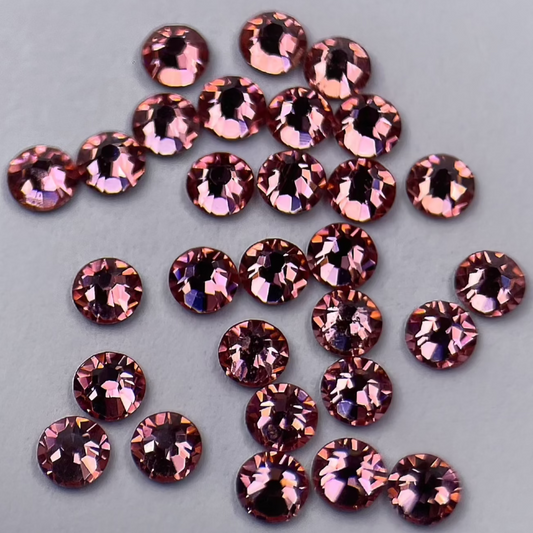 Zoom sur strass dentaire rond, teinte pêche douce.