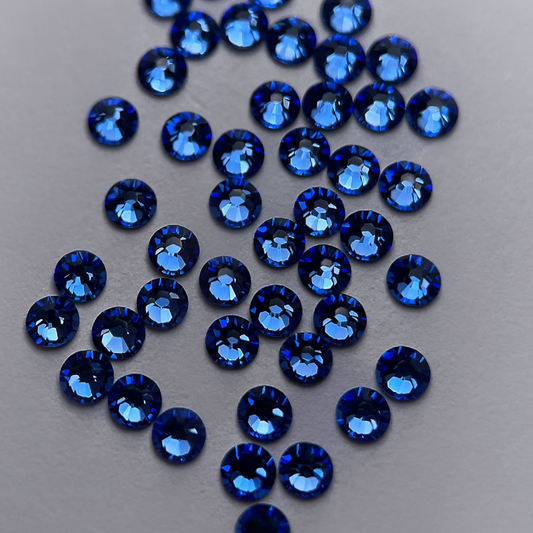 Zoom sur strass rond saphir à la brillance profonde.