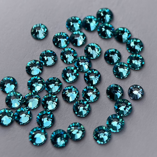 Zoom sur strass rond turquoise éclatant.