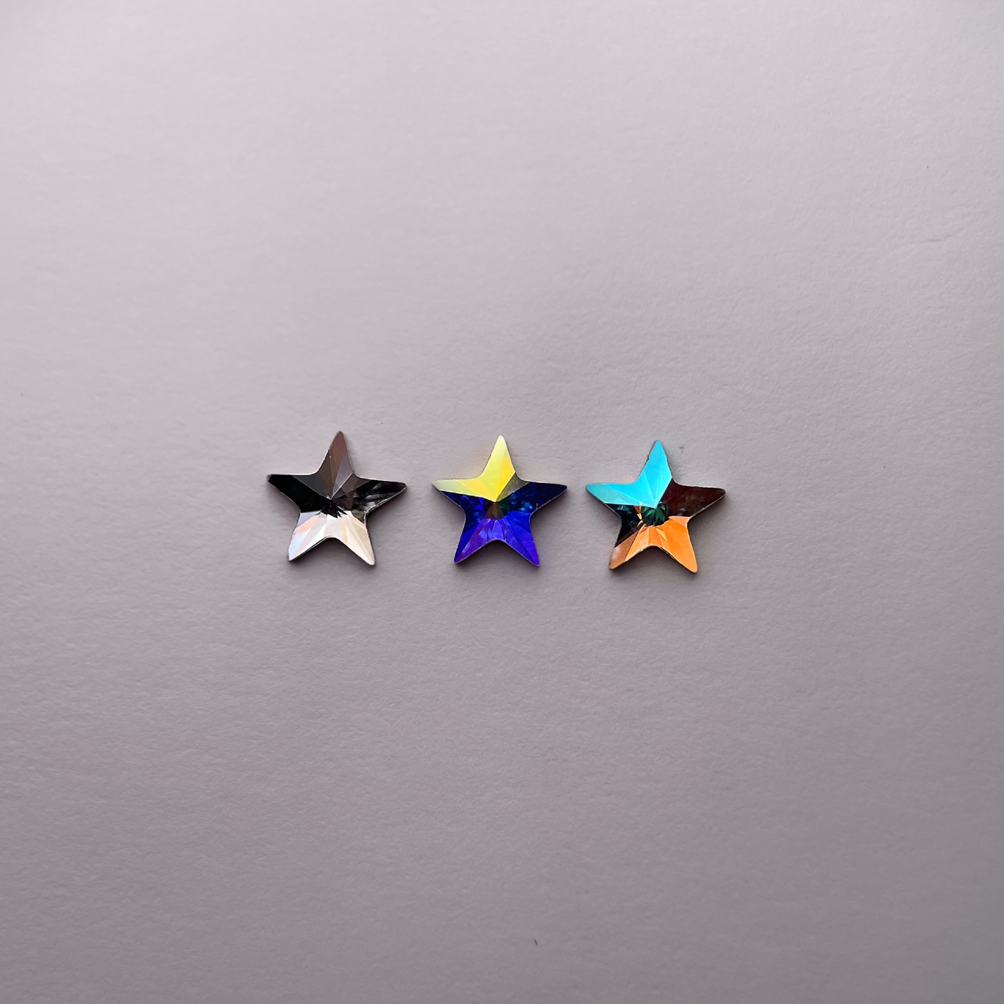 Trois strass dentaires Swarovski en forme d’étoile large, aux couleurs variées pour un sourire éclatant.