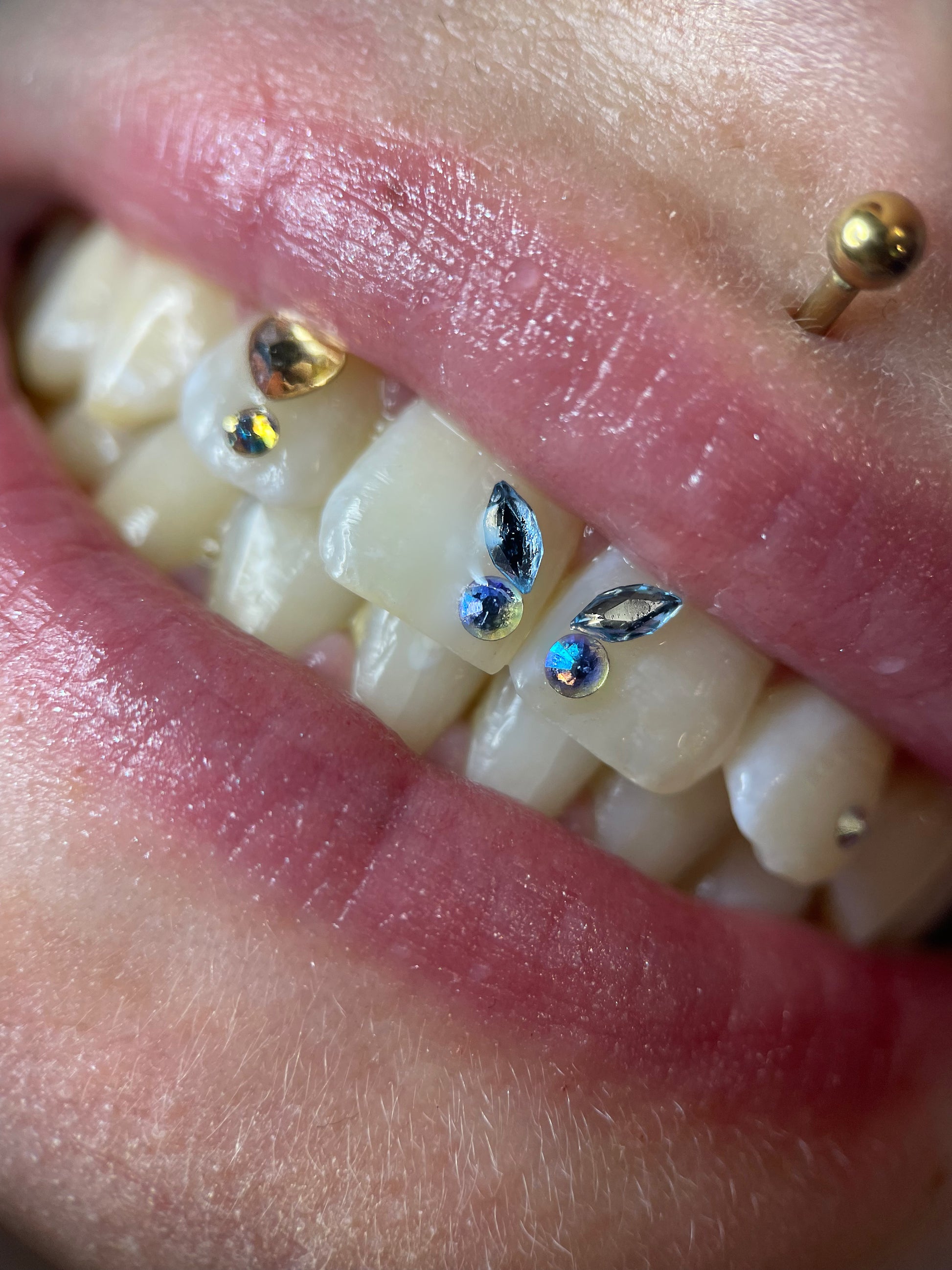 Sourire orné d'un papillon formé avec deux navette swarovski skyblue et deux ronds assortis
