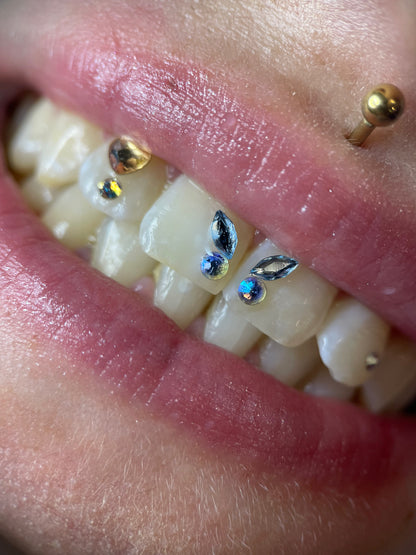 Sourire orné d'un papillon formé avec deux navette swarovski skyblue et deux ronds assortis