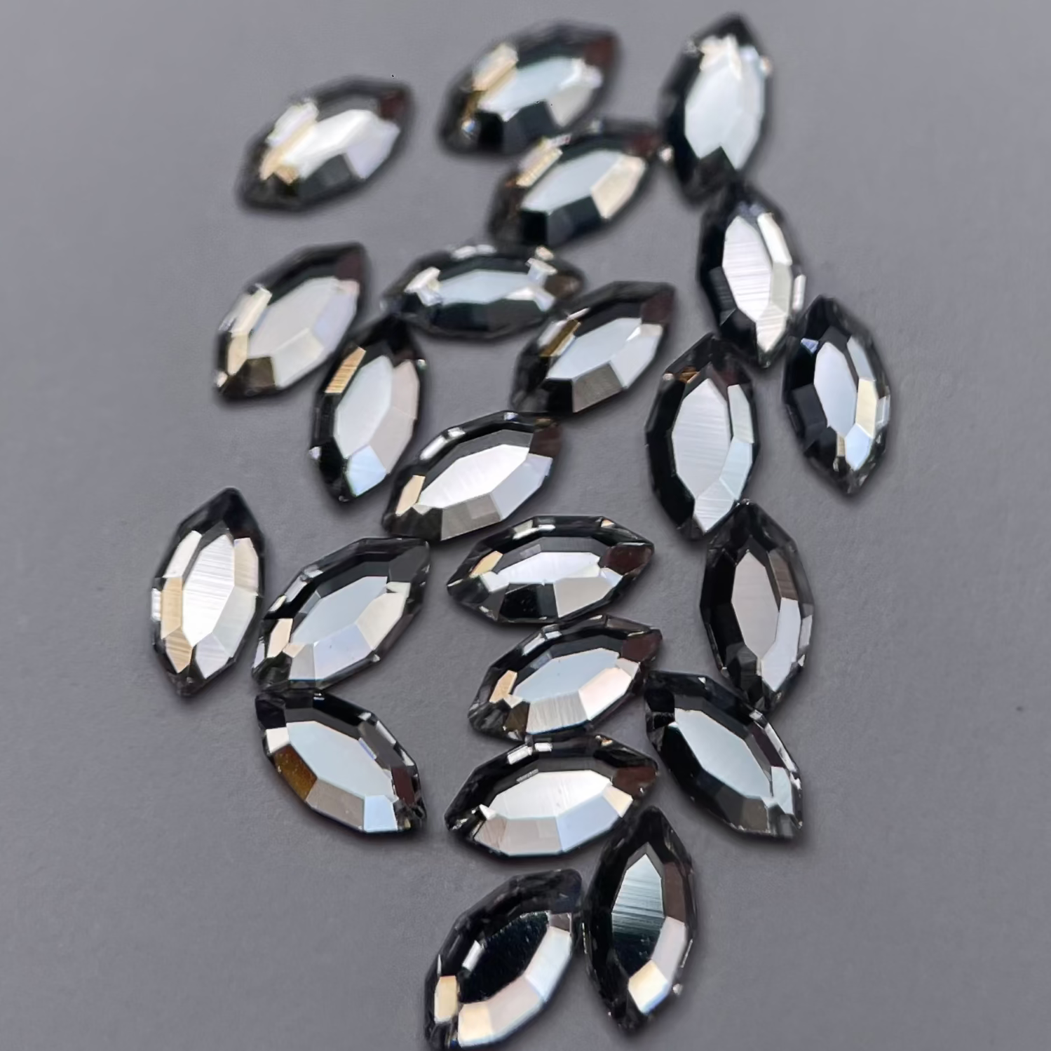 Gros plan sur strass dentaire Swarovski en forme de navette, couleur crystal, haute brillance, qualité professionnelle.