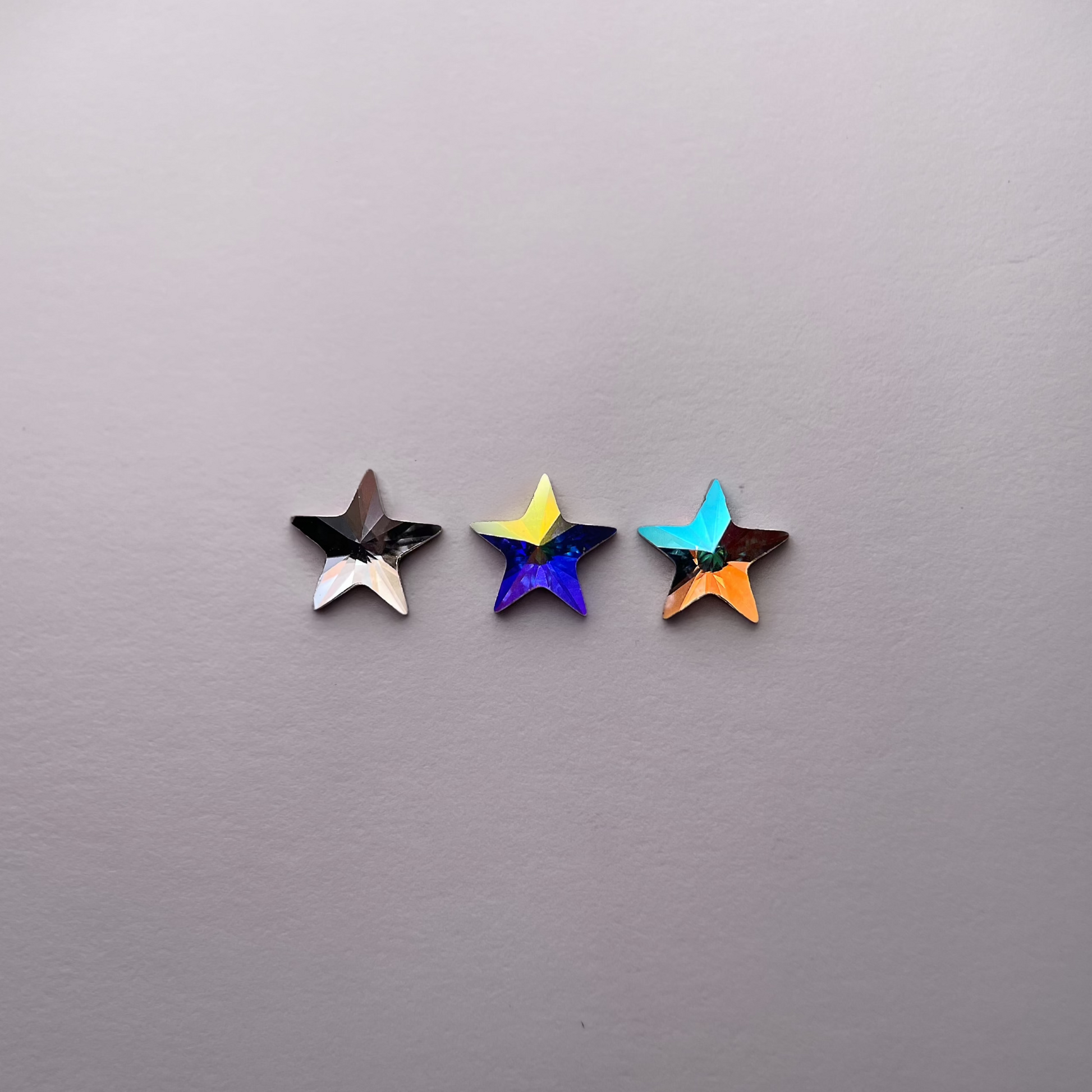 Trois strass dentaires Swarovski en forme d’étoile large, aux couleurs variées pour un sourire éclatant.